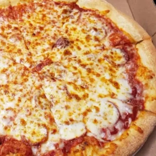 A close-up of a freshly baked, sliced pepperoni pizza with melted cheese in a cardboard box.